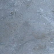 A man is riding a skateboard on a slate surface.