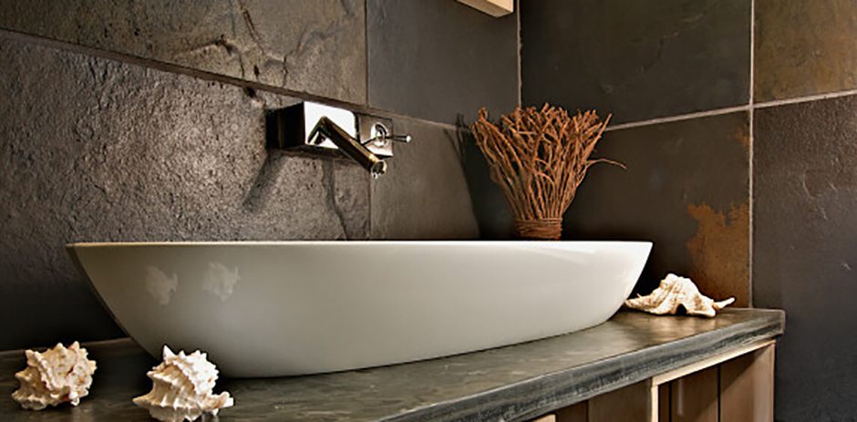 A white sink in a slate bathroom.