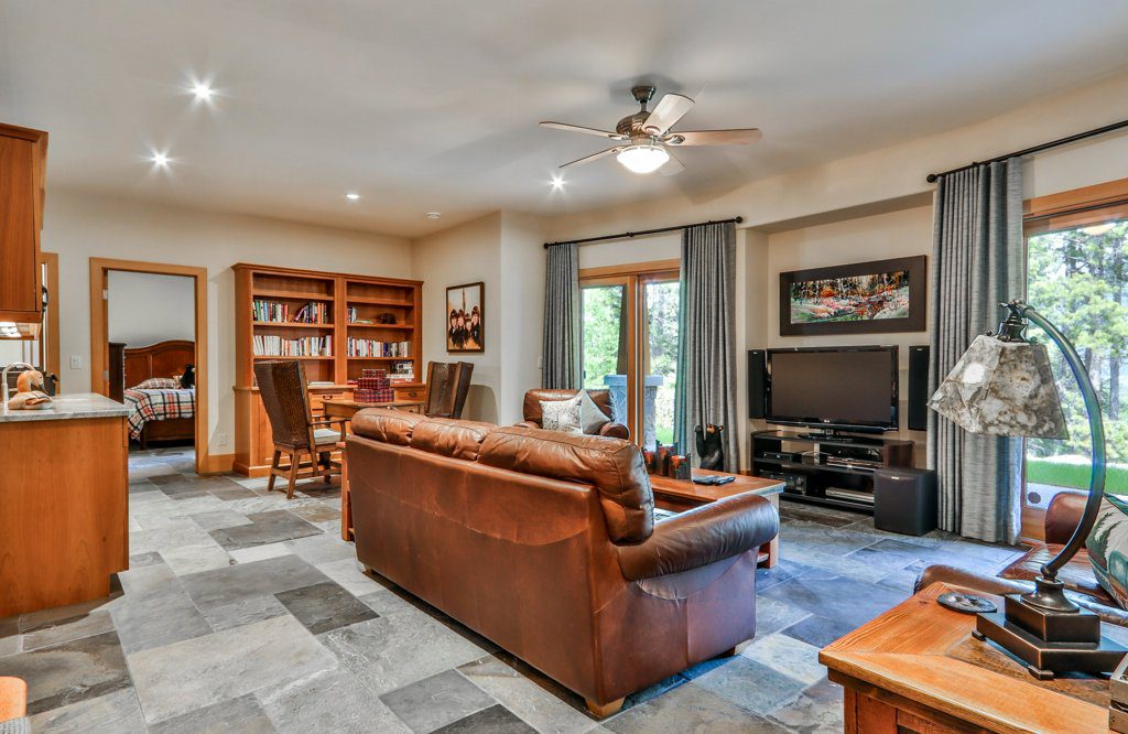 A living room with a couch in the middle and book shelves in the back